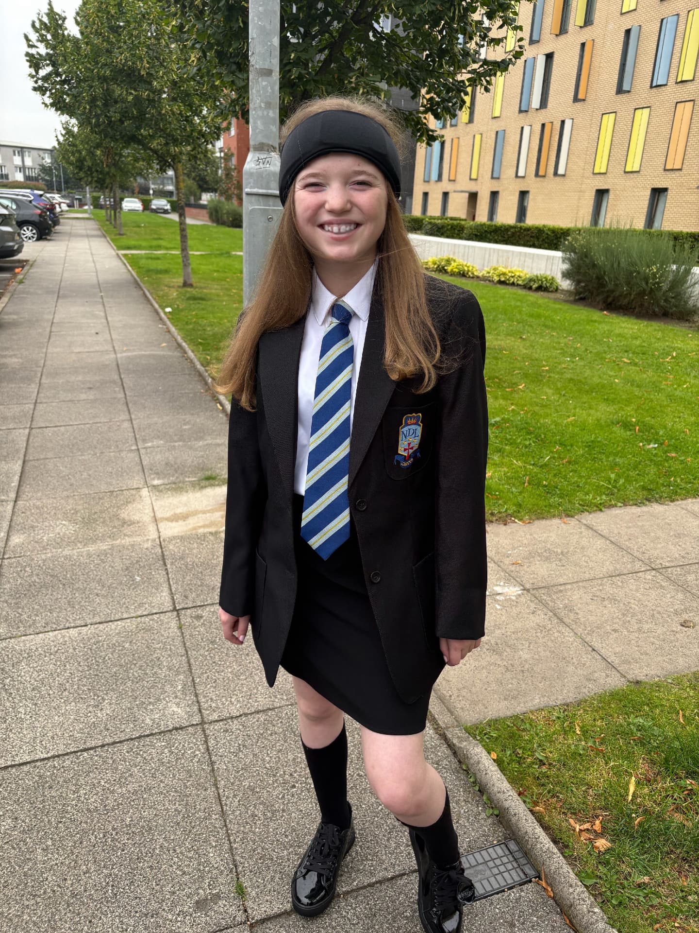 Olivia smiling in her new high school uniform on her first day